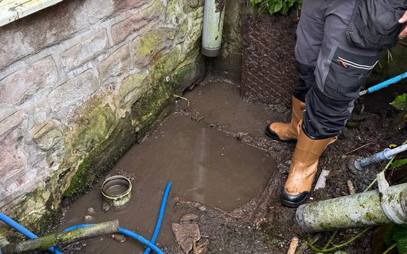 Plumber working on outside drain