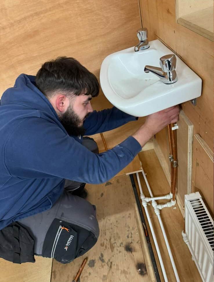 Plumber working on basin