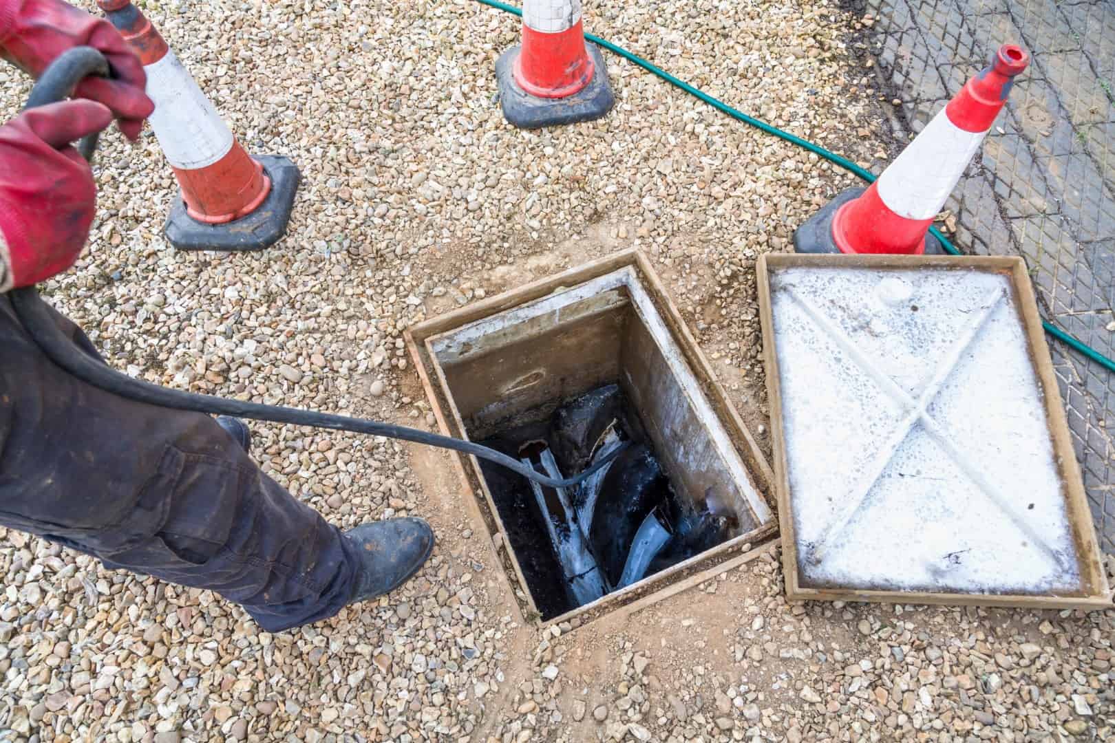 Plumber using tool to clear drains